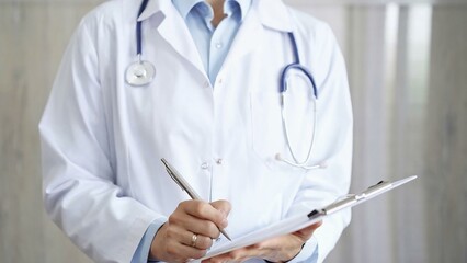 Female doctor filling medical form on clipboard, writing prescription, making notes. Medicine and science