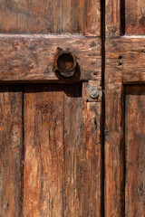 Close-Up of Round Metal Knocker on Rustic Wooden Italian Door