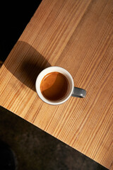 An 8oz espresso placed on a brown wooden table.