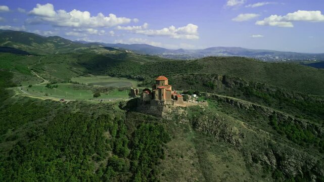 aerial view, there is a small temple on the mountain, a copter is flying around it in a circle, a warm sunny day, clear sky, mountains, a tourist near the temple, a river at the bottom of the mountain