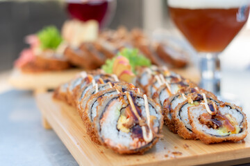 Rolls and sushi on a plate surrounded by vegetables and spices, Sushi and rolls, Japanese sea cuisine,Dragon Rolls at home,  Roll is another popular sushi roll serve, 