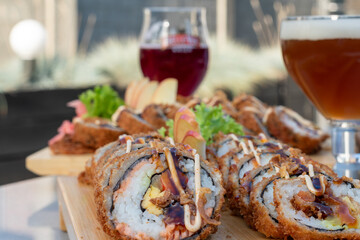 Rolls and sushi on a plate surrounded by vegetables and spices, Sushi and rolls, Japanese sea cuisine,Dragon Rolls at home,  Roll is another popular sushi roll serve,