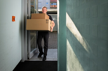 Delivery person holding large packages.