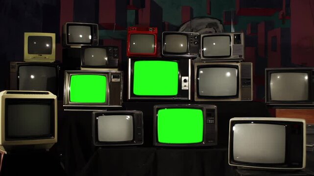 Vintage TV Stack: Nine Green Screens Power On Among 80s and 90s Sets - Replace the green screen with your chosen footage using the 'Keying' effect (see tutorials) - 4K
