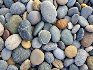 A smooth river stone texture, with different shades of gray and soft, rounded edges