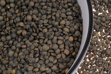 Assiette de lentilles du Puy sèches vue de dessus en gros plan sur fond de lentilles sèches