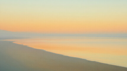 Obraz premium A breathtaking view of the sunset over a serene shoreline, with the sky painted in beautiful pastel hues, evoking a sense of calm and peaceful reflection.