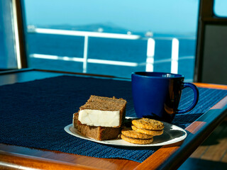 A cup of coffee with cookies on a table. There is a mug filled with aromatic espresso.