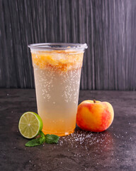 Refreshing Peach Mojitos made with peaches, lime juice, mint leaves, and sparkling water served in glass isolated dark background side view of healthy drink