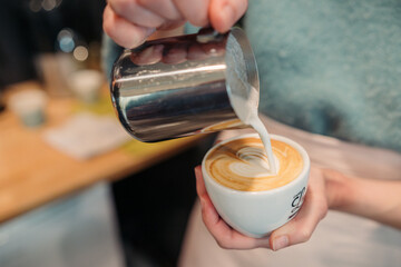 barista making a heart on a coffee