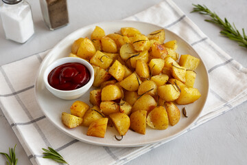 Homemade Oven Roasted Potatoes with Ketchup on a Plate, side view.