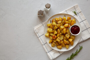 Homemade Oven Roasted Potatoes with Ketchup on a Plate, top view. Copy space.