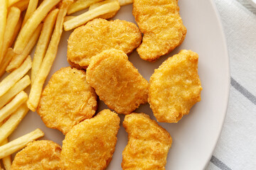 Fried Chicken Nuggets with French Fries on a Plate, top view. Overhead, from above, flat lay.