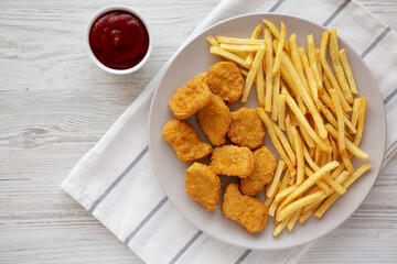 Fried Chicken Nuggets with French Fries on a Plate, top view. Overhead, from above, flat lay.