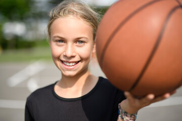 girl child in sportswear playing basketball game