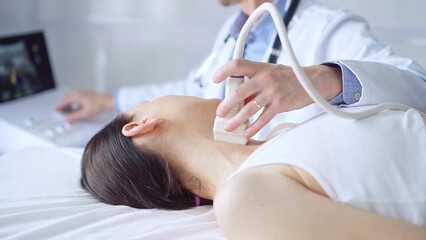Doctor man is using ultrasound equipment on neck of female patient lying down for a medical examination. Medicine and science