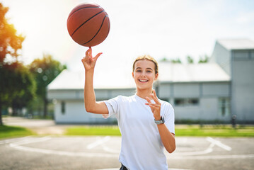 girl child in sportswear playing basketball game