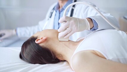 Doctor man is using ultrasound equipment on neck of female patient lying down for a medical examination. Medicine and science