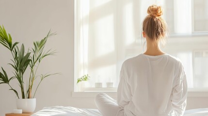 A serene scene featuring a person meditating by a window, surrounded by natural light and indoor plants, promoting relaxation and tranquility.