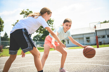 two childs girls in sportswear playing basketball game
