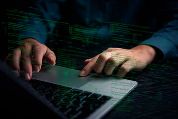 A close-up of hands typing on a laptop keyboard with digital code overlay, representing software...