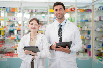 team man and woman pharmacist inspects a medication bottle, ensuring accuracy in prescription filling. pharmacists in patient safety and careful medication handling. operations in retail pharmacy.