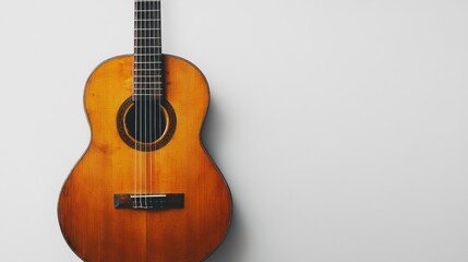 Obraz premium A classic guitar with a polished wooden finish, lying on a pristine white surface, emphasizing its simple beauty.