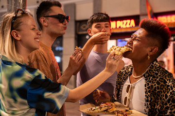 Diverse friends sharing pizza on LGBTQIA+ night out