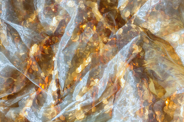 Gold sequin background with white silk folds on top.