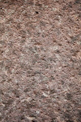 Old brown stone wall with many hole for abstract seamless background and texture. beautiful patterns, space for work, close up.Vertical.