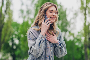 Portrait of nice young girl chatting phone laugh wear denim jacket pastime walk city downtown park outdoors