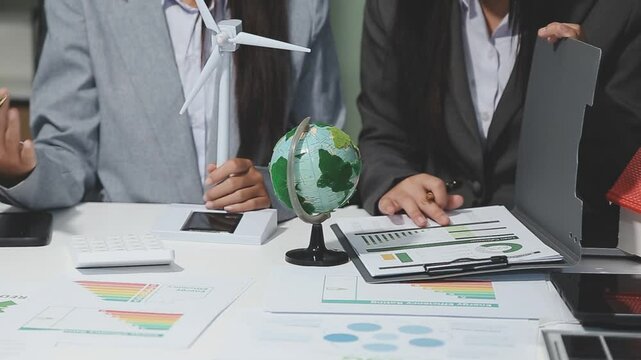 Diverse group of business people discussing for alternative energy utilization for greener sustainable Earth by reducing CO2 emission and carbon credit with renewable clean energy technology. Quaint