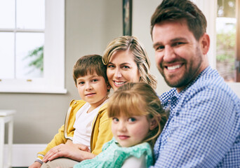 Family, portrait and smile in house for relax, bonding and support with parents, love and care. Mom, dad and children in living room for comfort, relationship and embrace together on weekend on sofa