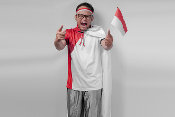Young Indonesian man wearing jersey with flag draped over shoulder holding a mini country flag.