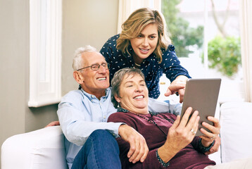 Woman, tablet and elderly couple on sofa for help, learning and showing new app at home. Senior parents, daughter and tech in living room for communication, streaming and relax on couch with media