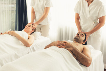 Obraz premium Caucasian couple enjoying relaxing anti-stress head massage and pampering facial beauty skin recreation leisure in dayspa modern light ambient at luxury resort or hotel spa salon. Quiescent