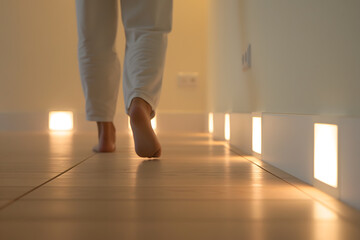 person walking barefoot at home, closeup. Floor heating concept