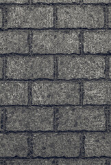 Stone wall made of rectangular blocks with decoratively hewn and processed edges in black and white. The stonework has a small pattern and an almost smooth relief. Monotonous neutral background.
