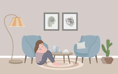 A girl in a psychologist’s office sits on the floor and holds her head with her hands. A psychologist's office, a cozy room with two armchairs, a floor lamp, paintings, paper napkins and a cactus. 