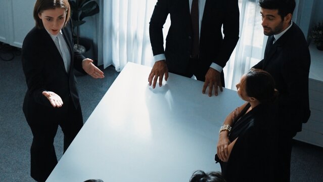 Top view of project manager looking at meeting table surrounded by diverse business people brainstorm and planning strategy. Group of smart people discussing and solve business problems. Directorate.