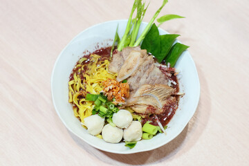 Yellow noodles decorated with pork meatballs, sliced ​​pork, vegetables and pork blood soup.