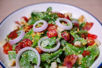 Healthy vegetable salad of fresh tomato, onion, lettuce  on plate. Diet menu. Top view.