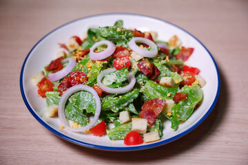 Healthy vegetable salad of fresh tomato, onion, lettuce  on plate. Diet menu. Top view.