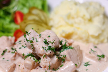 Chicken in cream sauce served with mashed potatoes and salad.