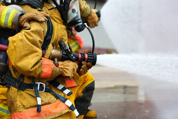 Close up of hand Firefighter  high pressure spraying water to stop fire.