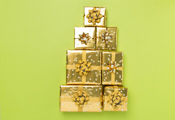 Gift boxes in Christmas tree shape on color background, top view