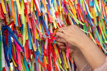Female hand holding Brazilian ribbon (Lembranca do Senhor do Bonfim) from Salvador, Bahia...