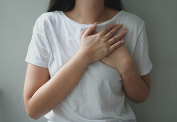 Young asian woman having clutching chest with heart anatomy, heart disease, female holing her pain area and standing, sick woman suffering from acute heart attack, World Heart Day Concept.