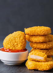 Delicious chicken nuggets on black background. Cooked or raw chicken nuggets