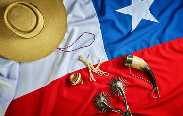fondo con espuelas, cacho, chupalla emboquillado y trompo sobre la bandera de Chile, concepto...
